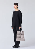 A model wears the BAO BAO ISSEY MIYAKE PRISM tote.