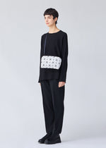 A model wears the BAO BAO ISSEY MIYAKE CARTON shoulder bag.