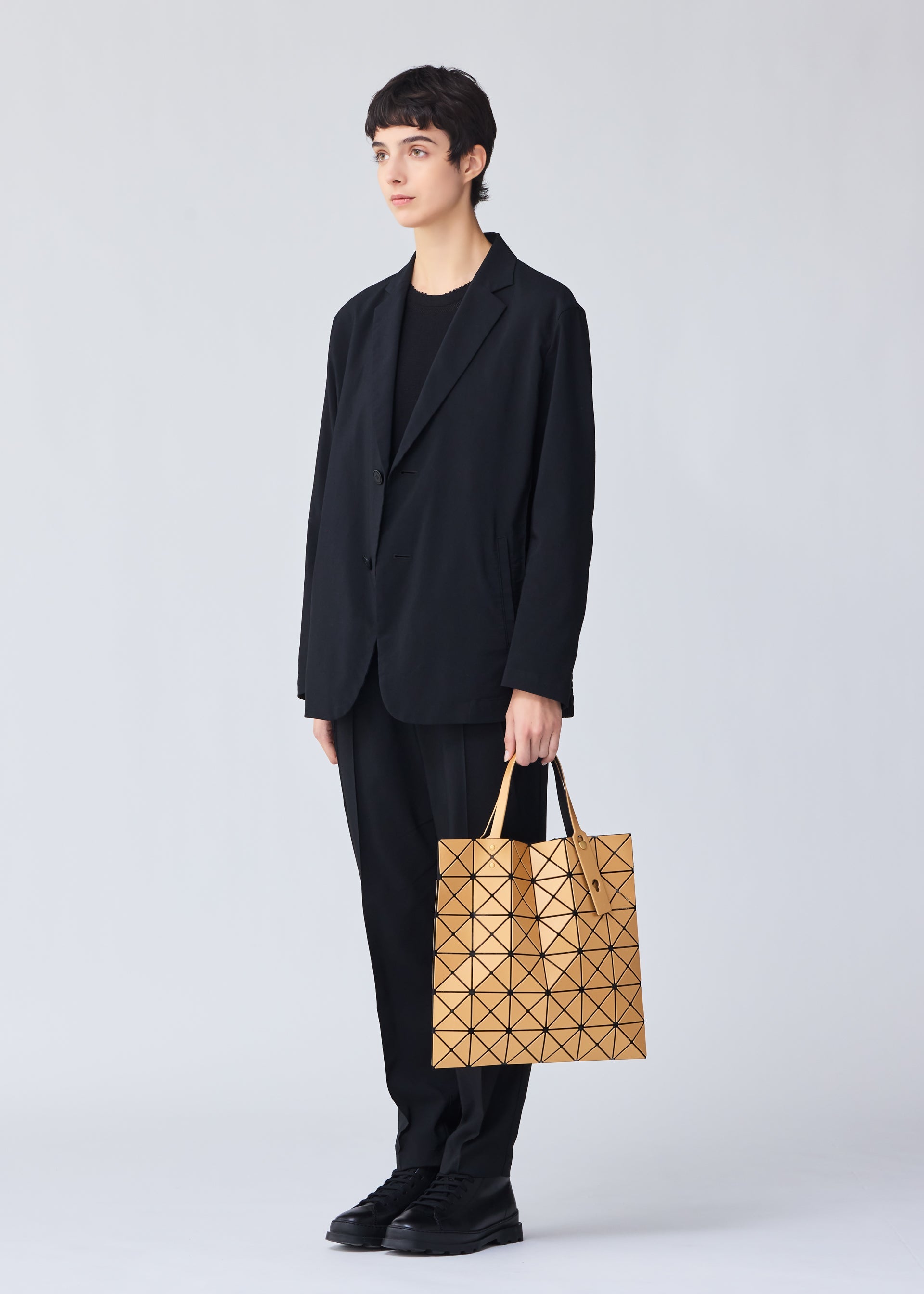 A model wears the BAO BAO ISSEY MIYAKE LUCENT METALLIC tote.