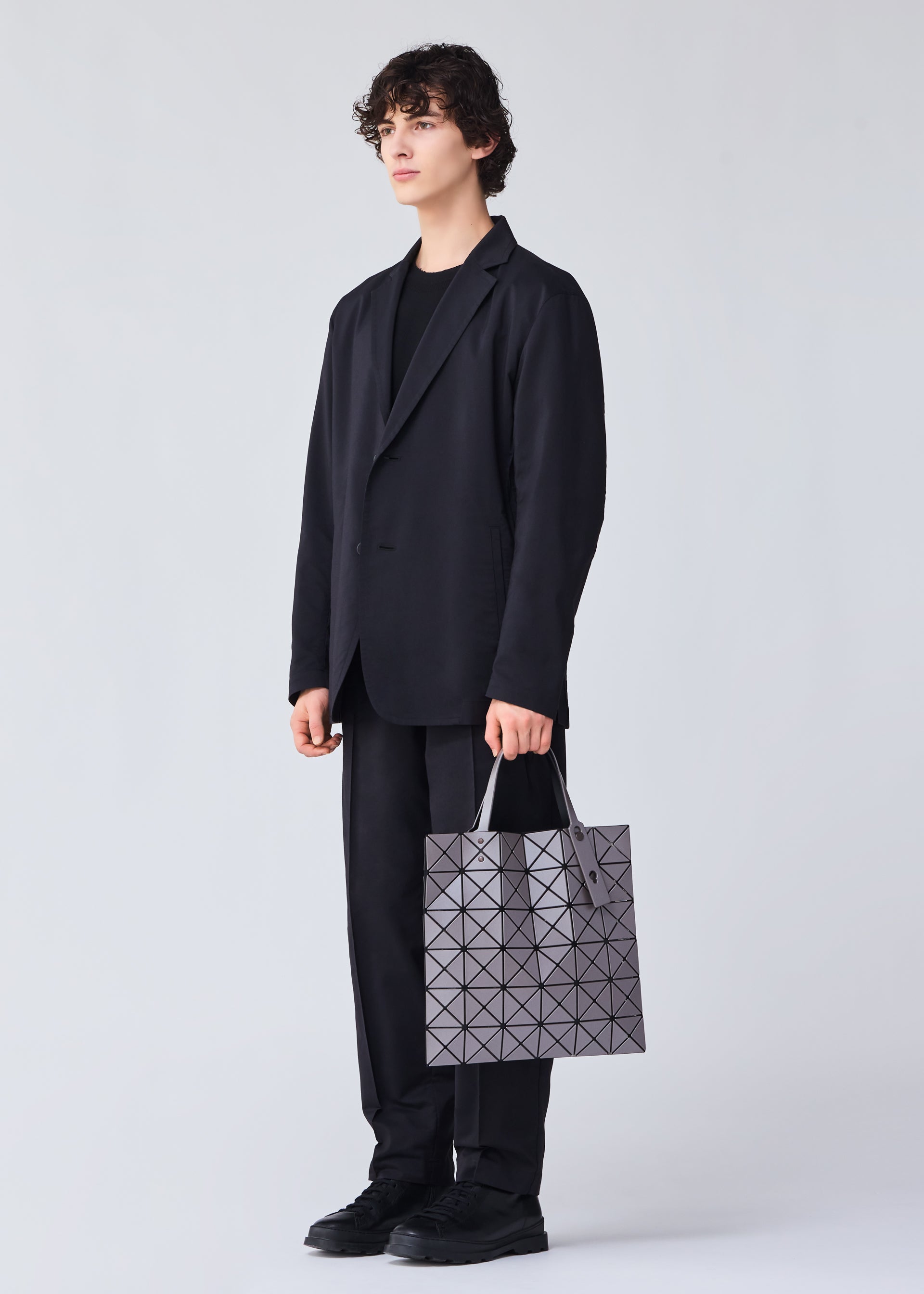 A model wears the BAO BAO ISSEY MIYAKE LUCENT METALLIC tote.
