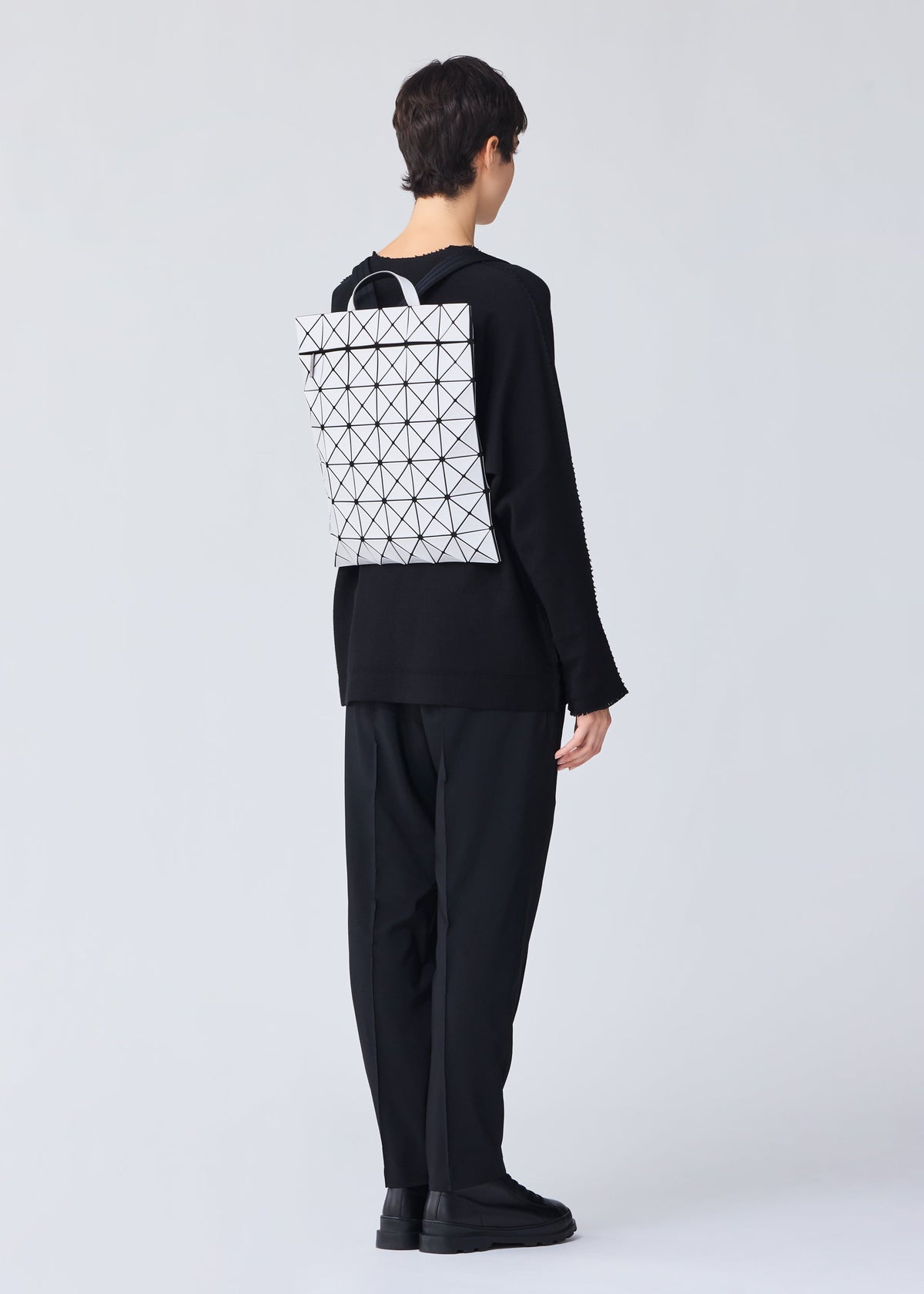 A model wears the BAO BAO ISSEY MIYAKE FLAT PACK backpack.