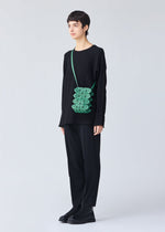 A model wears the BAO BAO ISSEY MIYAKE GROWTH shoulder bag.