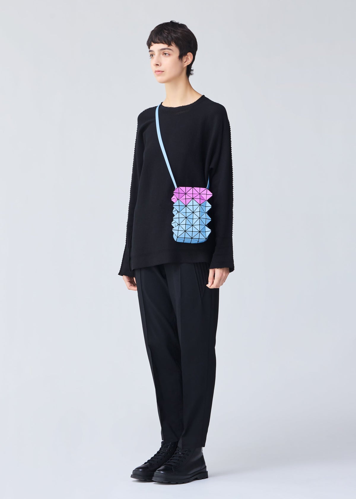 A model wears the BAO BAO ISSEY MIYAKE GROWTH shoulder bag.