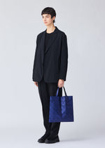 A model wears the BAO BAO ISSEY MIYAKE META KAIJU tote.