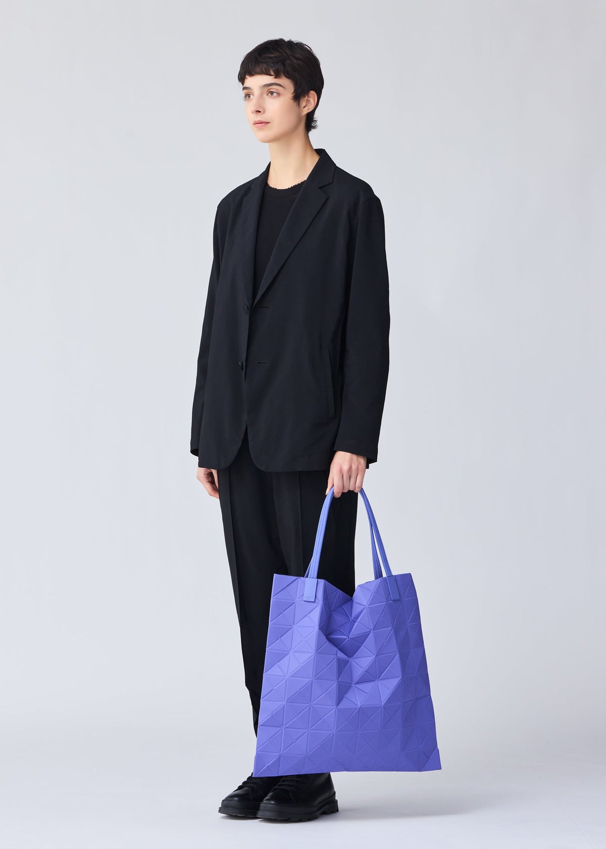 A model wears the BAO BAO ISSEY MIYAKE TRACK tote.