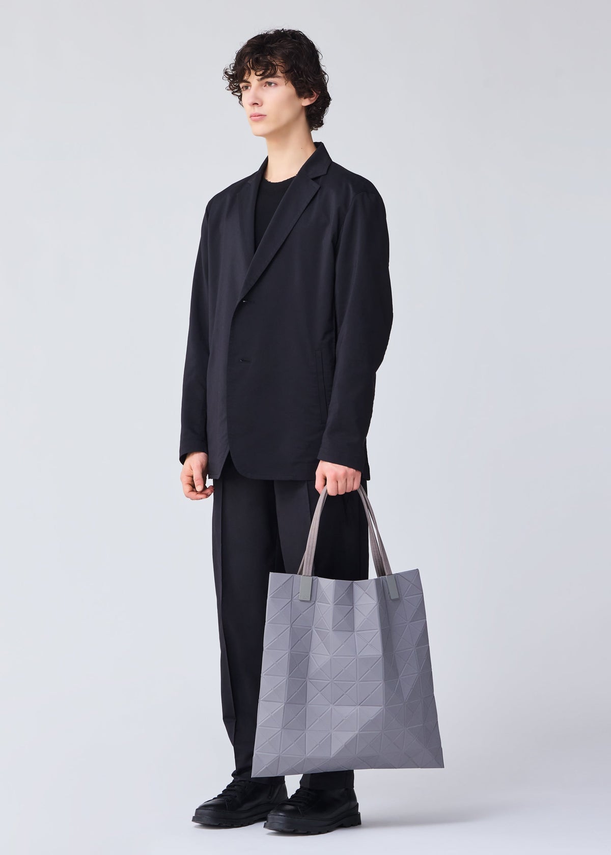 A model wears the BAO BAO ISSEY MIYAKE TRACK tote.