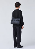 A model wears the BAO BAO ISSEY MIYAKE FROGGY shoulder bag.
