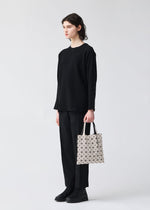 A model wears the BAO BAO ISSEY MIYAKE PRISM FROST tote.