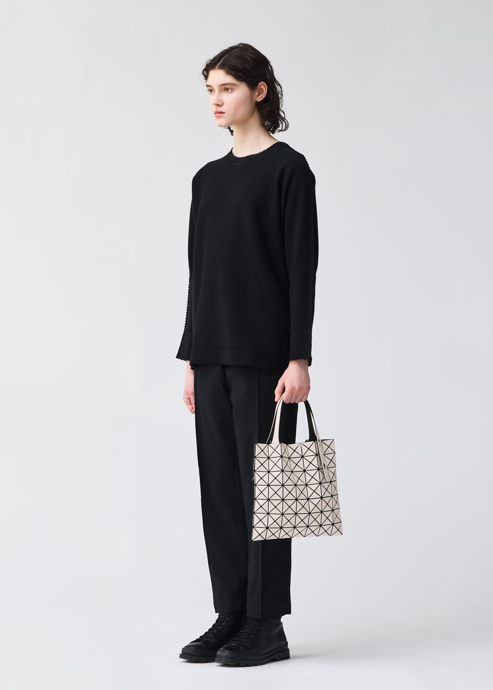 A model wears the BAO BAO ISSEY MIYAKE PRISM FROST tote.