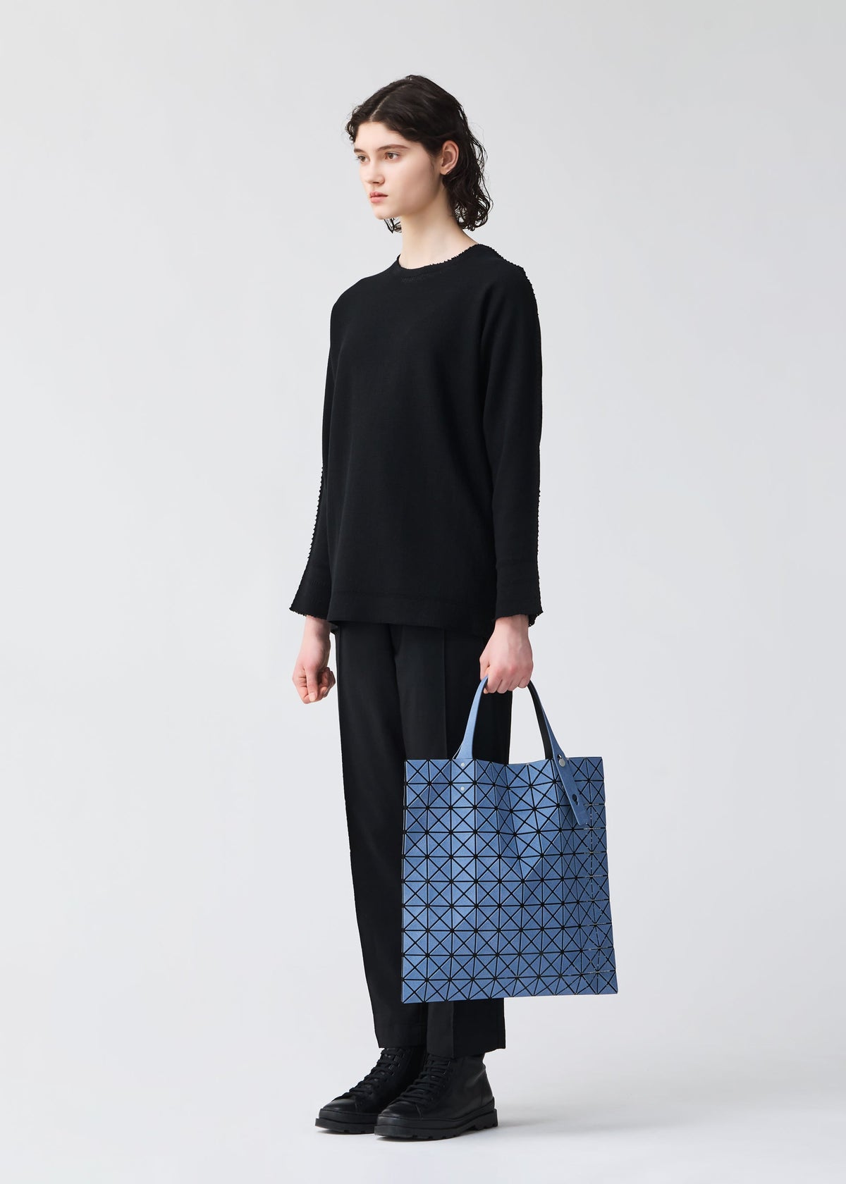 A model wears the BAO BAO ISSEY MIYAKE PRISM DENIM prism-denim-tote-blue.