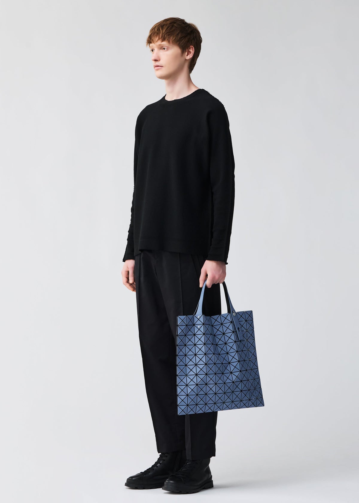 A model wears the BAO BAO ISSEY MIYAKE PRISM DENIM prism-denim-tote-black.