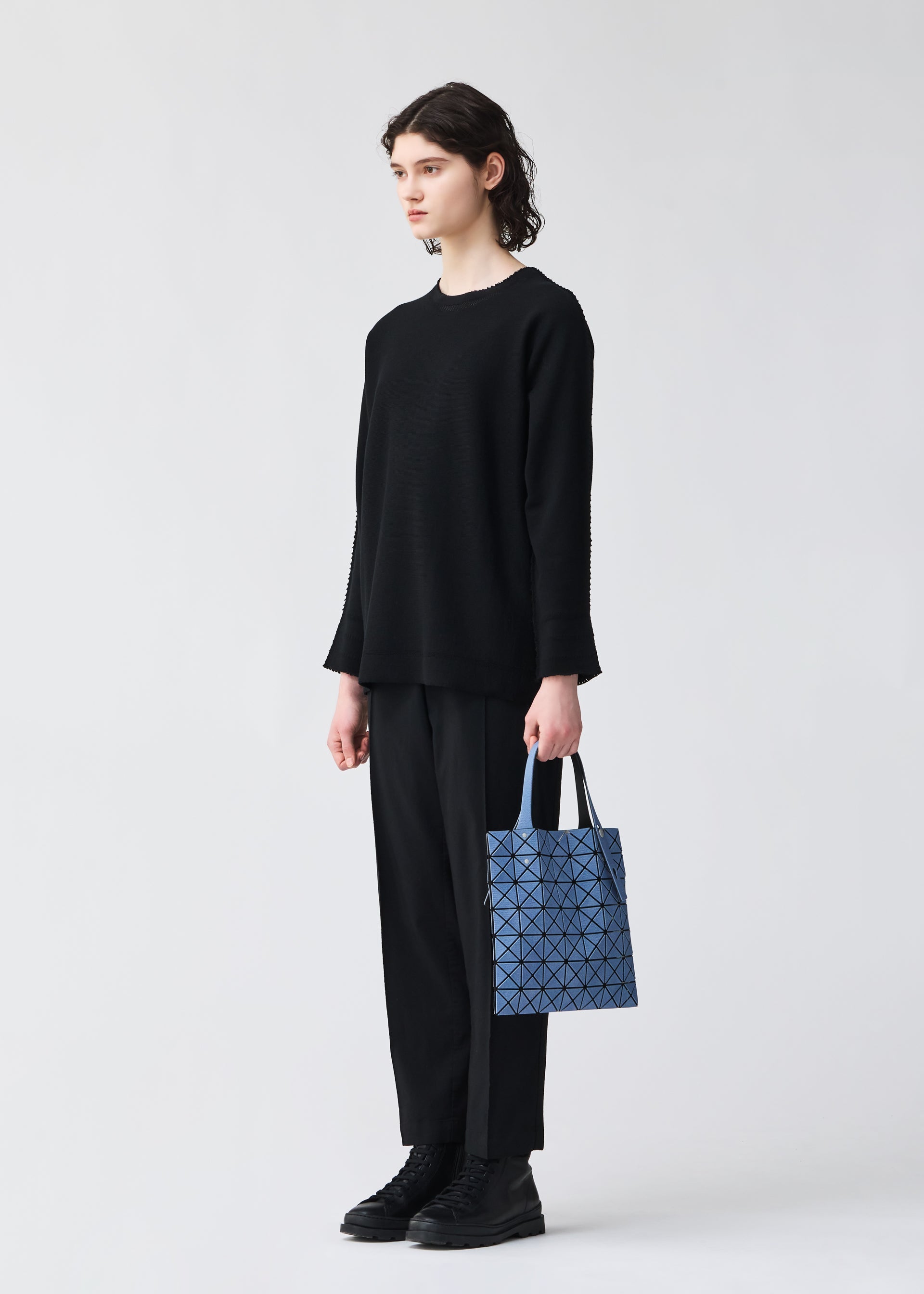A model wears the BAO BAO ISSEY MIYAKE PRISM DENIM prism-denim-tote-blue-1.