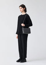 A model wears the BAO BAO ISSEY MIYAKE LOOP ONE TONE shoulder bag.