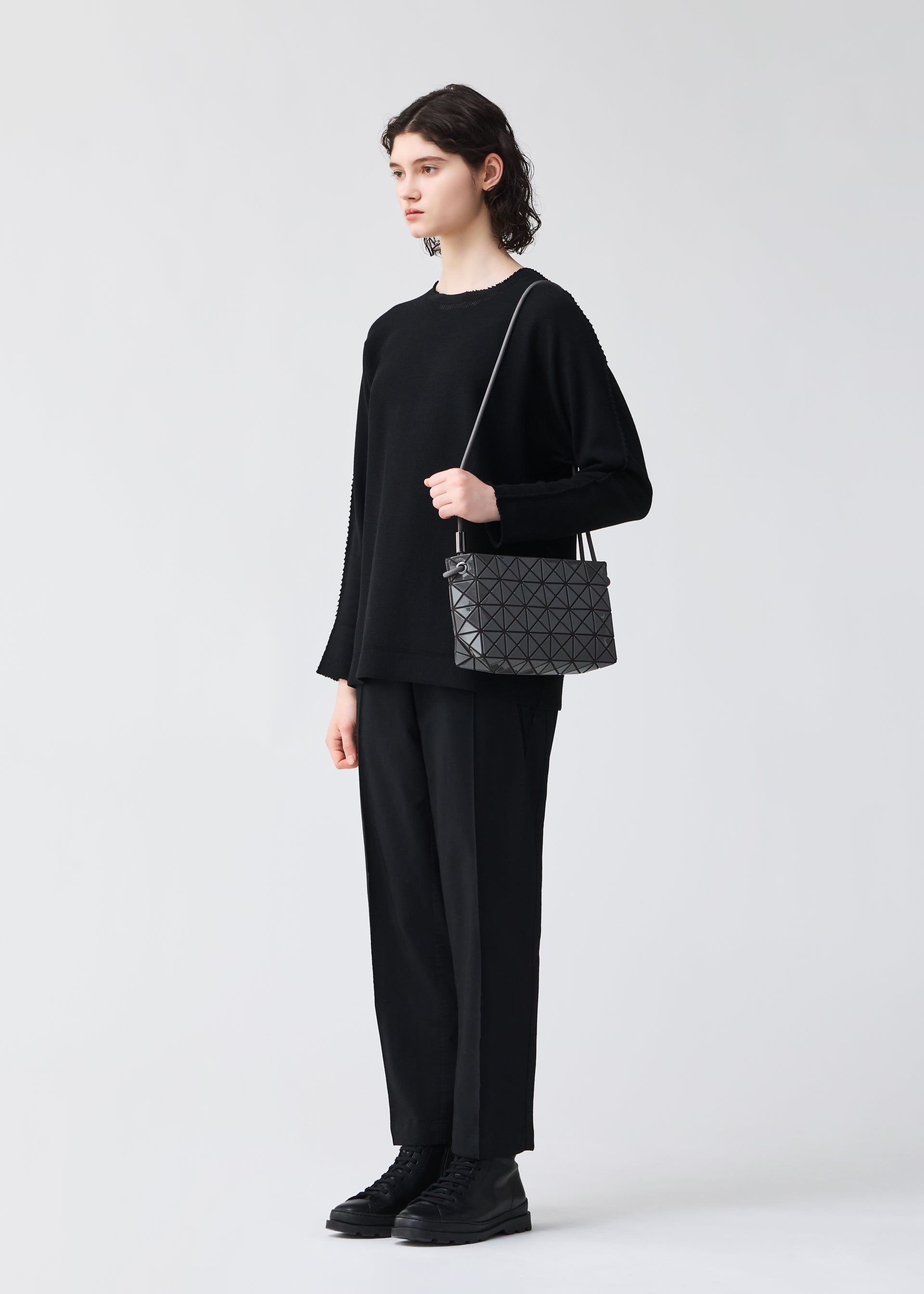 A model wears the BAO BAO ISSEY MIYAKE LOOP ONE TONE shoulder bag.