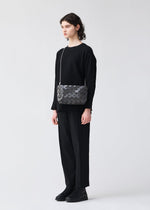 A model wears the BAO BAO ISSEY MIYAKE LOOP ONE TONE shoulder bag.