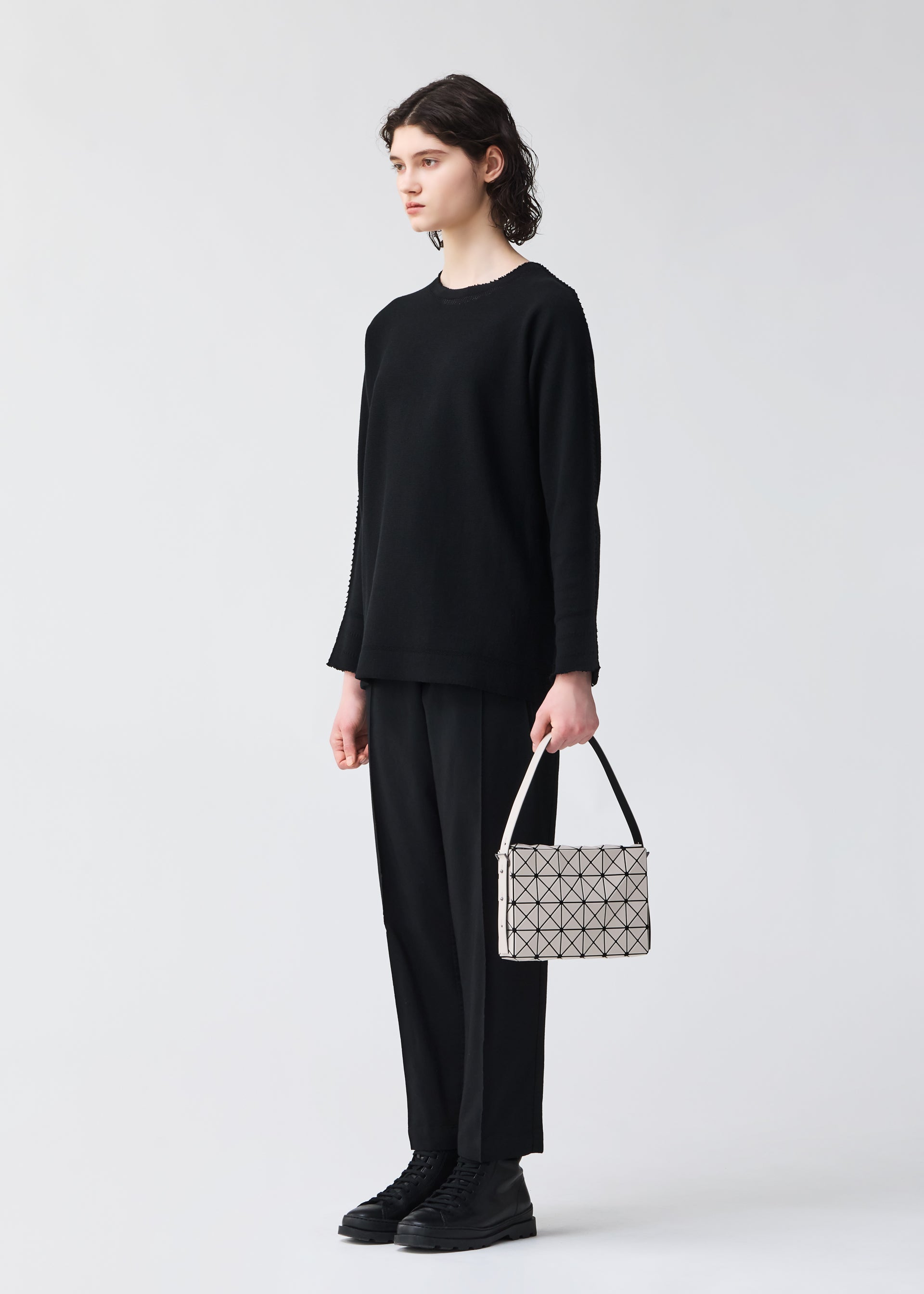 A model wears the BAO BAO ISSEY MIYAKE OBLONG oblong-shoulder-bag-matte-black.