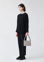A model wears the BAO BAO ISSEY MIYAKE OBLONG oblong-shoulder-bag-beige.