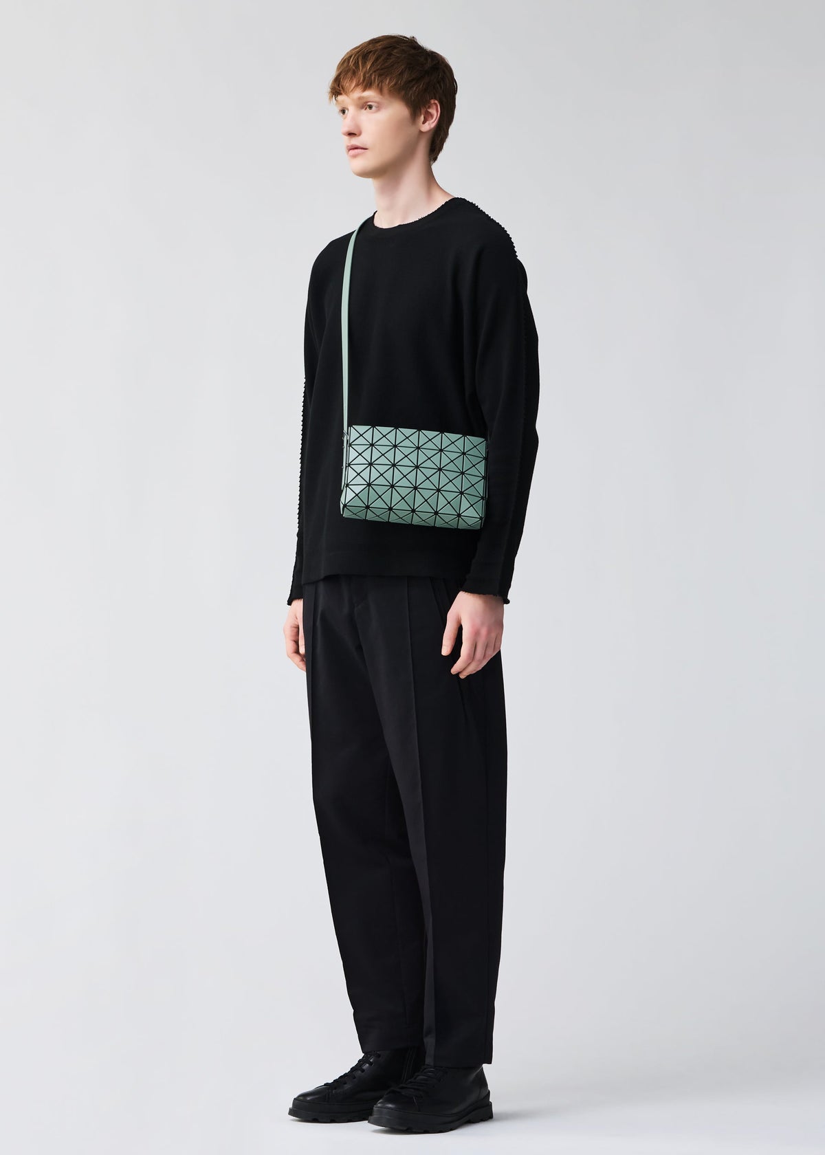A model wears the BAO BAO ISSEY MIYAKE OBLONG oblong-shoulder-bag-beige.