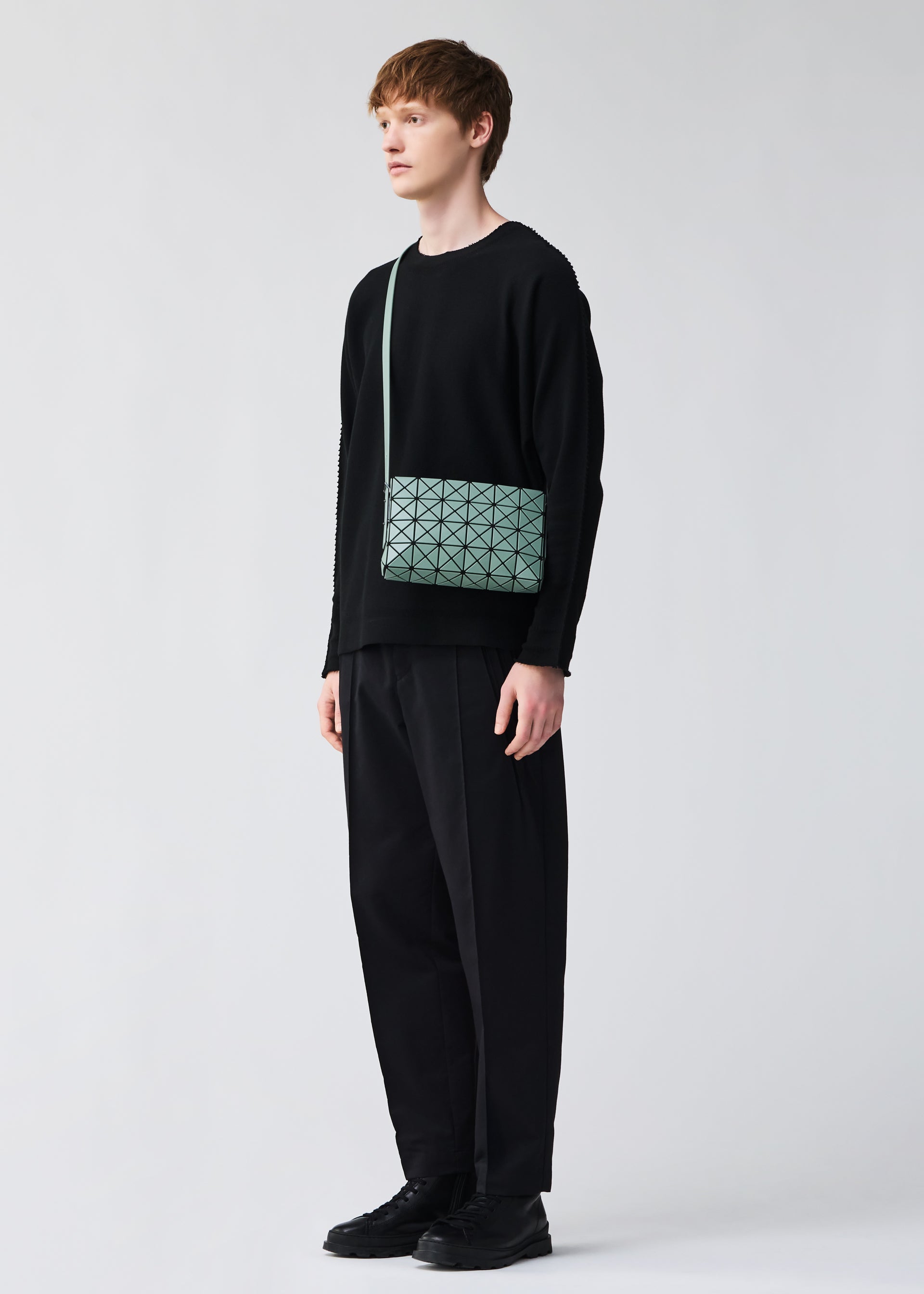 A model wears the BAO BAO ISSEY MIYAKE OBLONG oblong-shoulder-bag-matte-black.