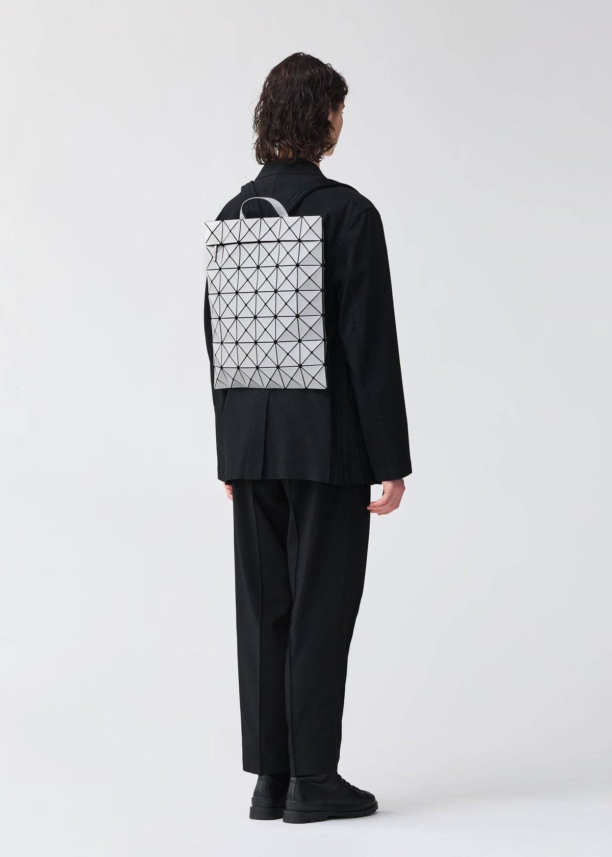 A model wears the BAO BAO ISSEY MIYAKE FLAT PACK backpack.