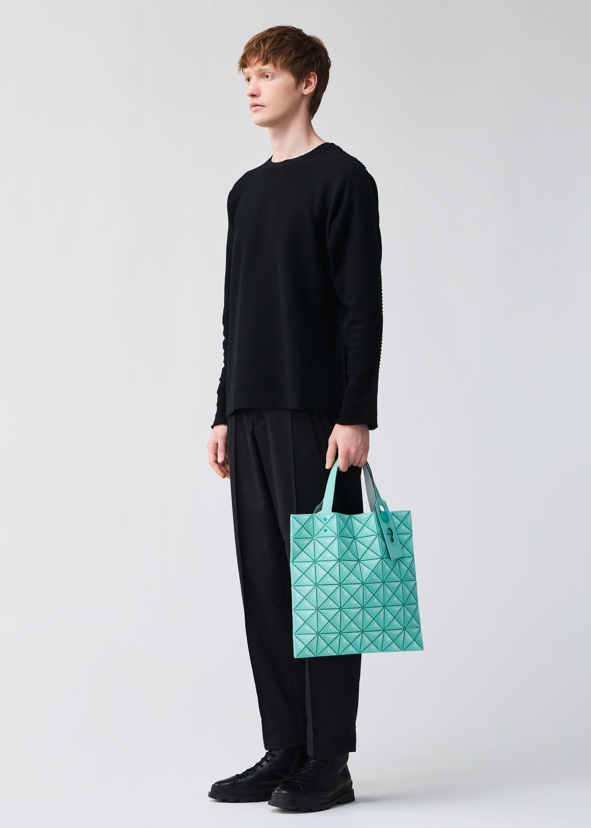 A model wears the BAO BAO ISSEY MIYAKE MINIATURE miniature-tote-grey.