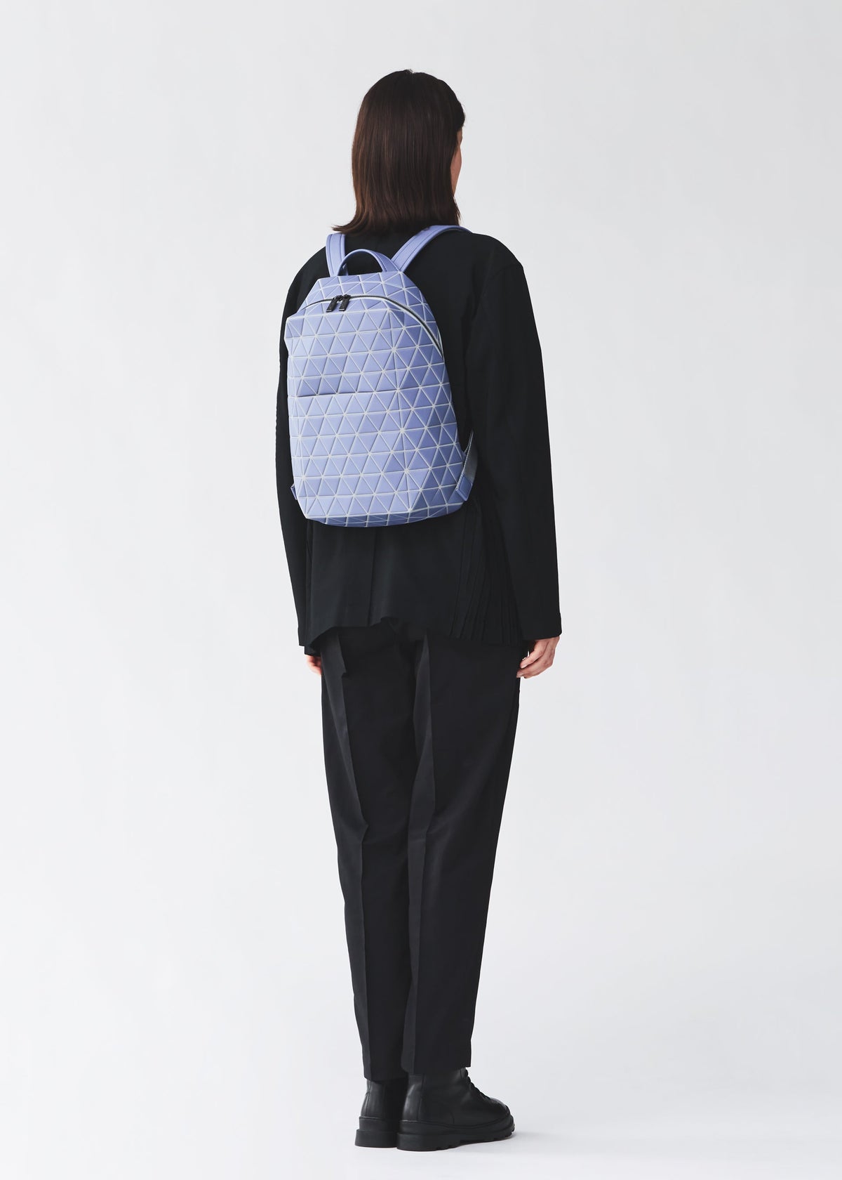 A model wears the BAO BAO ISSEY MIYAKE HEXAGON hexagon-adjustable-backpack-matte-black.