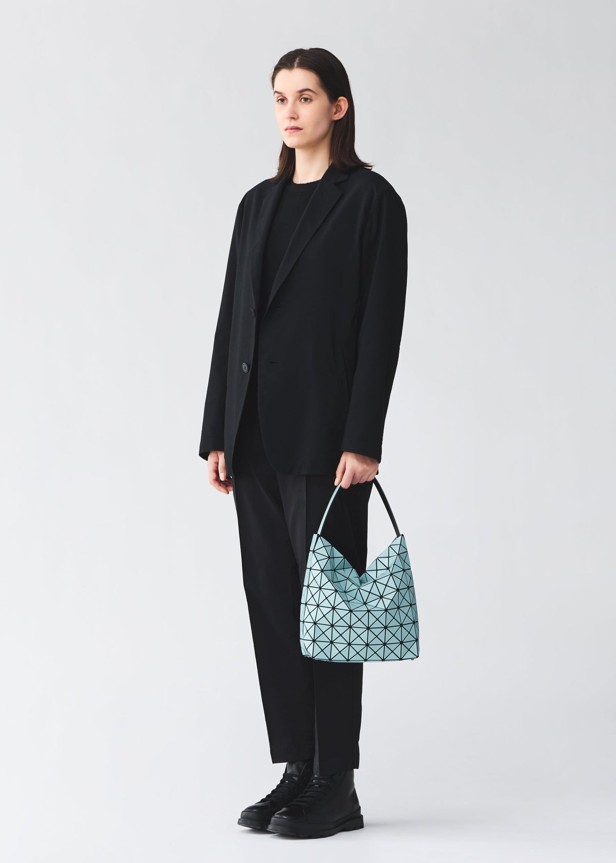 A model wears the BAO BAO ISSEY MIYAKE VALLEY valley-small-hand-bag-burgundy.