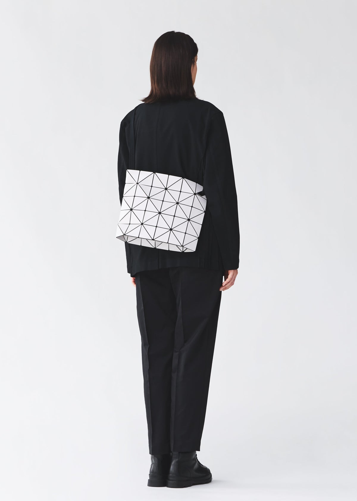 A model wears the BAO BAO ISSEY MIYAKE BLOCKY blocky-adjustable-shoulder-bag-matte-black.