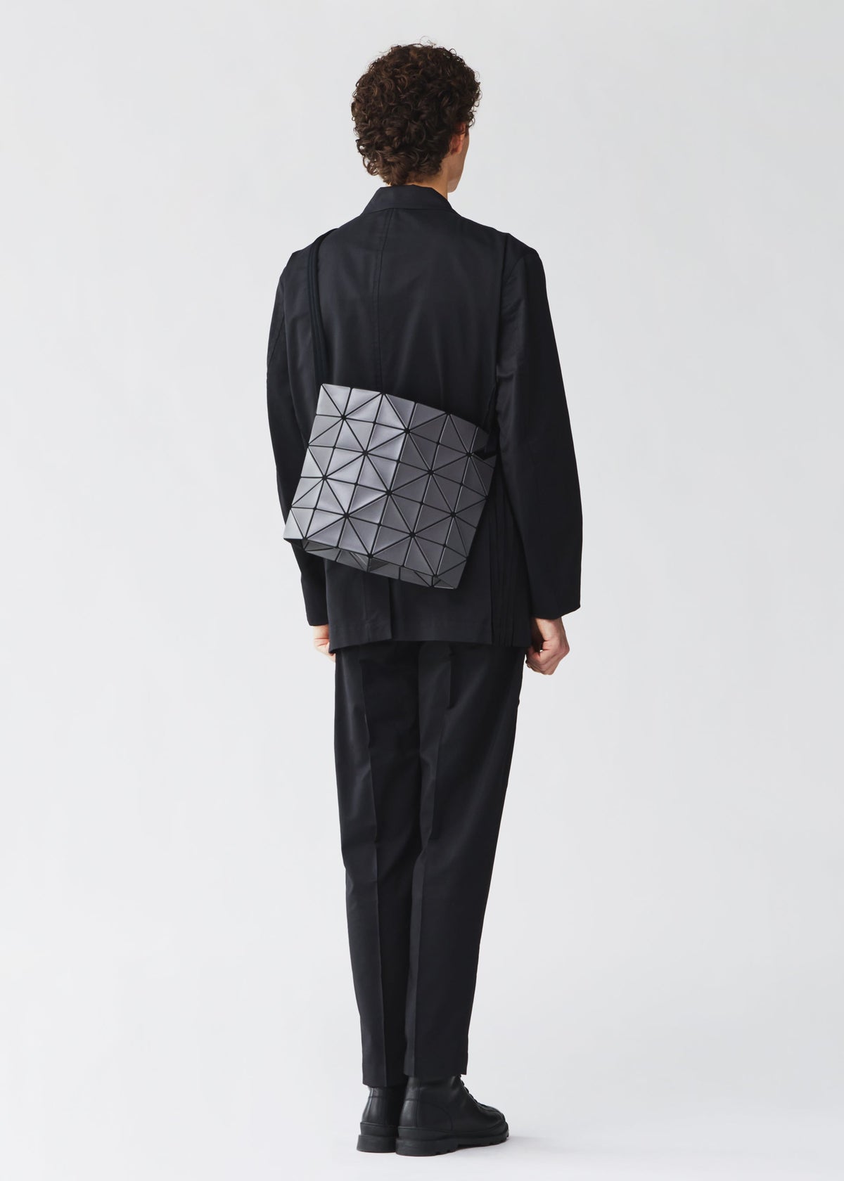 A model wears the BAO BAO ISSEY MIYAKE BLOCKY blocky-adjustable-shoulder-bag-matte-black.