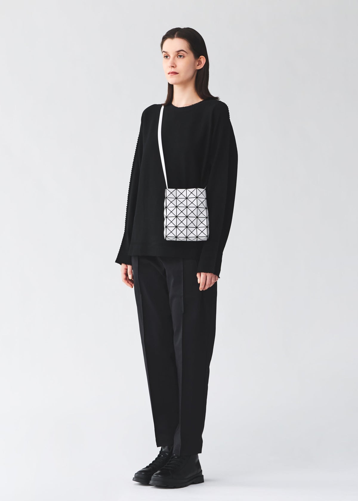 A model wears the BAO BAO ISSEY MIYAKE PRISM MATTE prism-matte-shoulder-bag-matte-black-1.