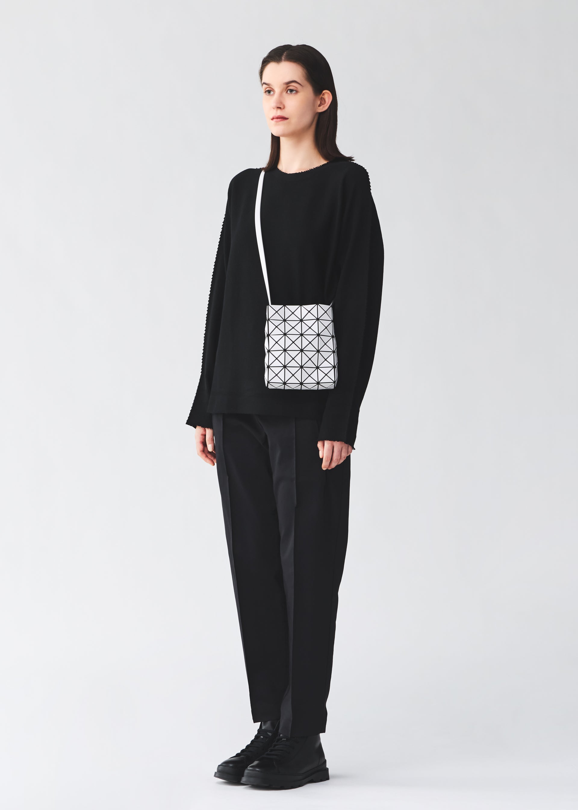 A model wears the BAO BAO ISSEY MIYAKE PRISM MATTE prism-matte-shoulder-bag-matte-black-1.