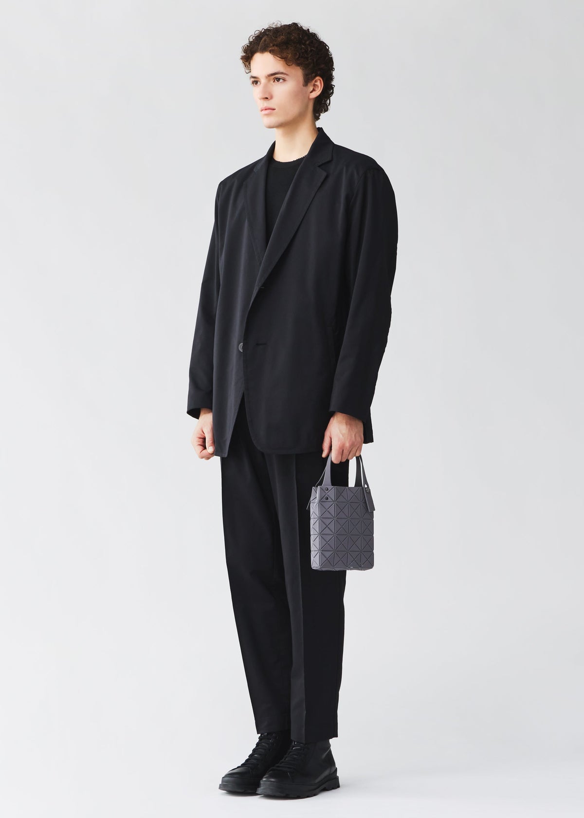 A model wears the BAO BAO ISSEY MIYAKE PRISM PLUS prism-plus-tote-ochre.