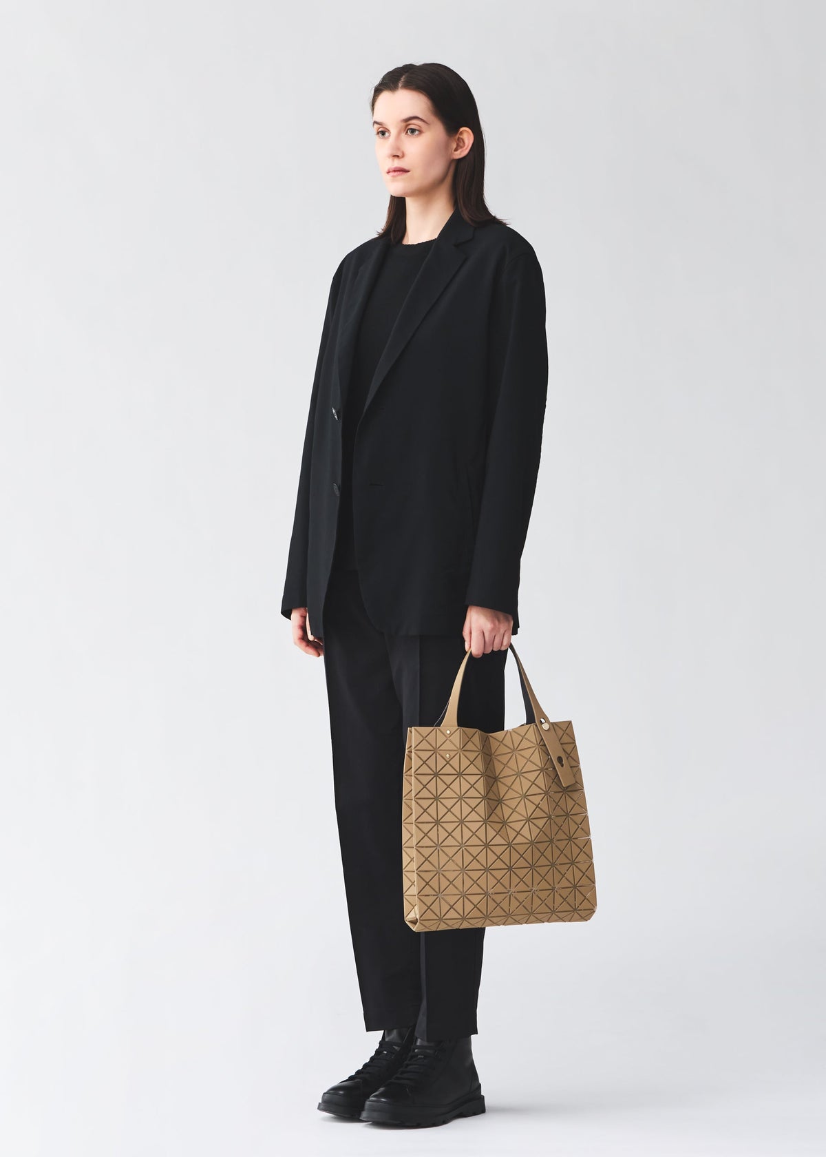 A model wears the BAO BAO ISSEY MIYAKE PRISM PLUS prism-plus-adjustable-tote-smoky-pink.
