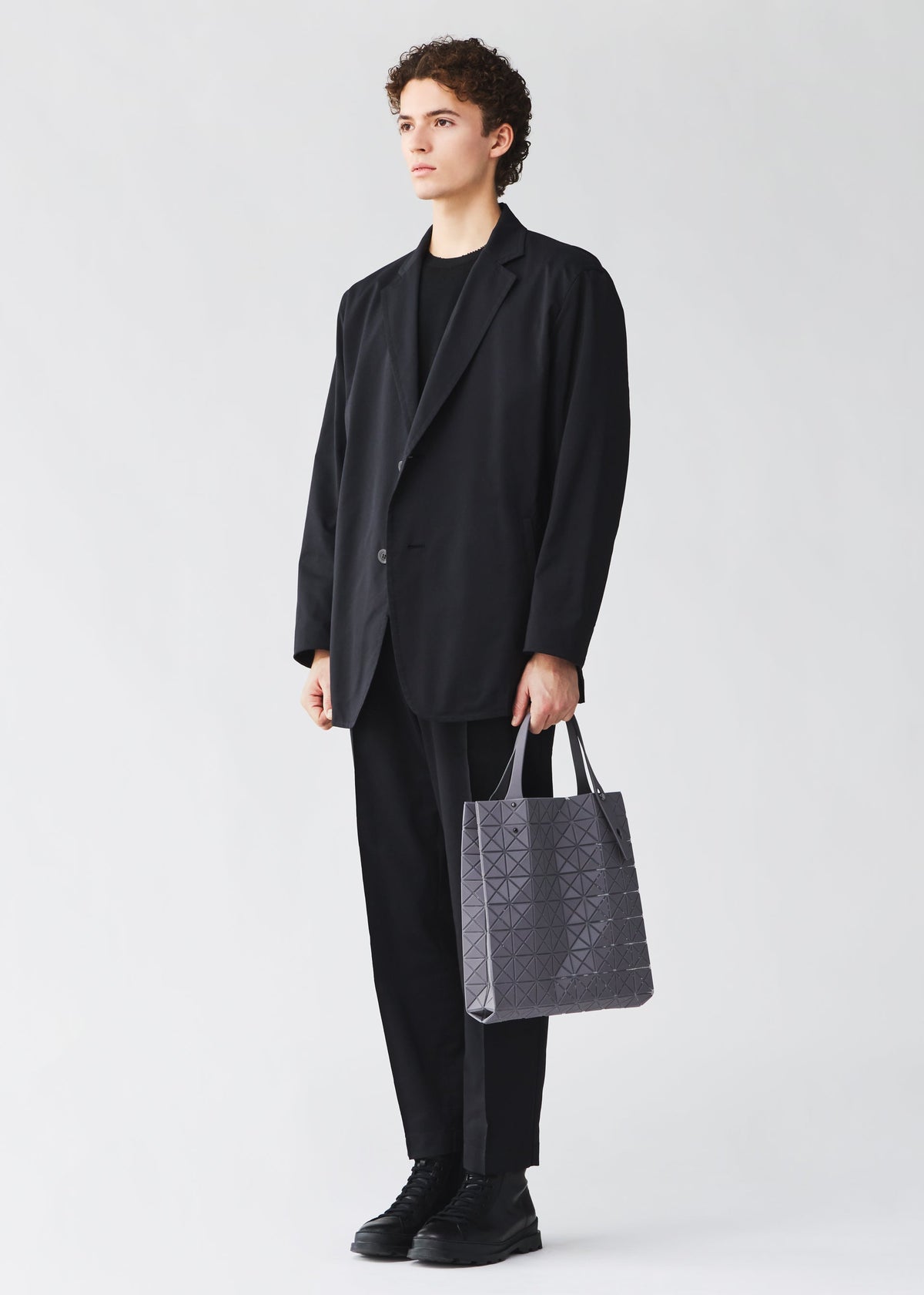 A model wears the BAO BAO ISSEY MIYAKE PRISM PLUS prism-plus-adjustable-tote-smoky-pink.