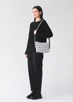 A model wears the BAO BAO ISSEY MIYAKE MUSETTE musette-shoulder-bag-light-brown.