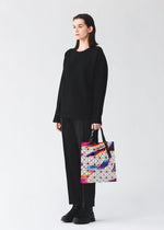 A model wears the BAO BAO ISSEY MIYAKE WARP warp-tote-white-mix.