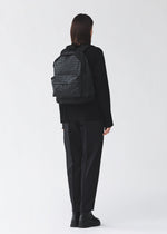 A model wears the BAO BAO ISSEY MIYAKE DAYPACK daypack-backpack-matte-black-2.