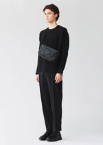 A model wears the BAO BAO ISSEY MIYAKE SADDLE BAG saddle-bag-shoulder-bag-matte-black-2.