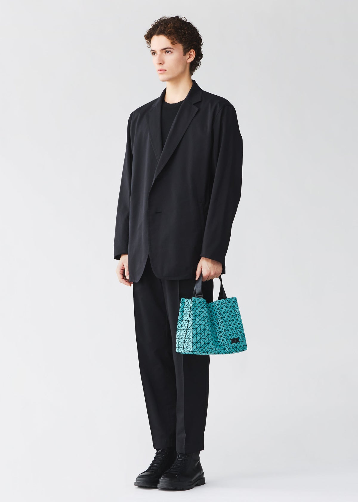 A model wears the BAO BAO ISSEY MIYAKE CART MINI cart-mini-tote-matte-black.