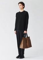 A model wears the BAO BAO ISSEY MIYAKE CART REFLECTOR cart-reflector-tote-copper-brown.