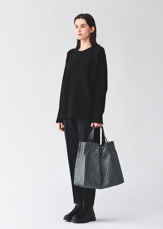 A model wears the BAO BAO ISSEY MIYAKE CART REFLECTOR cart-reflector-tote-copper-brown.