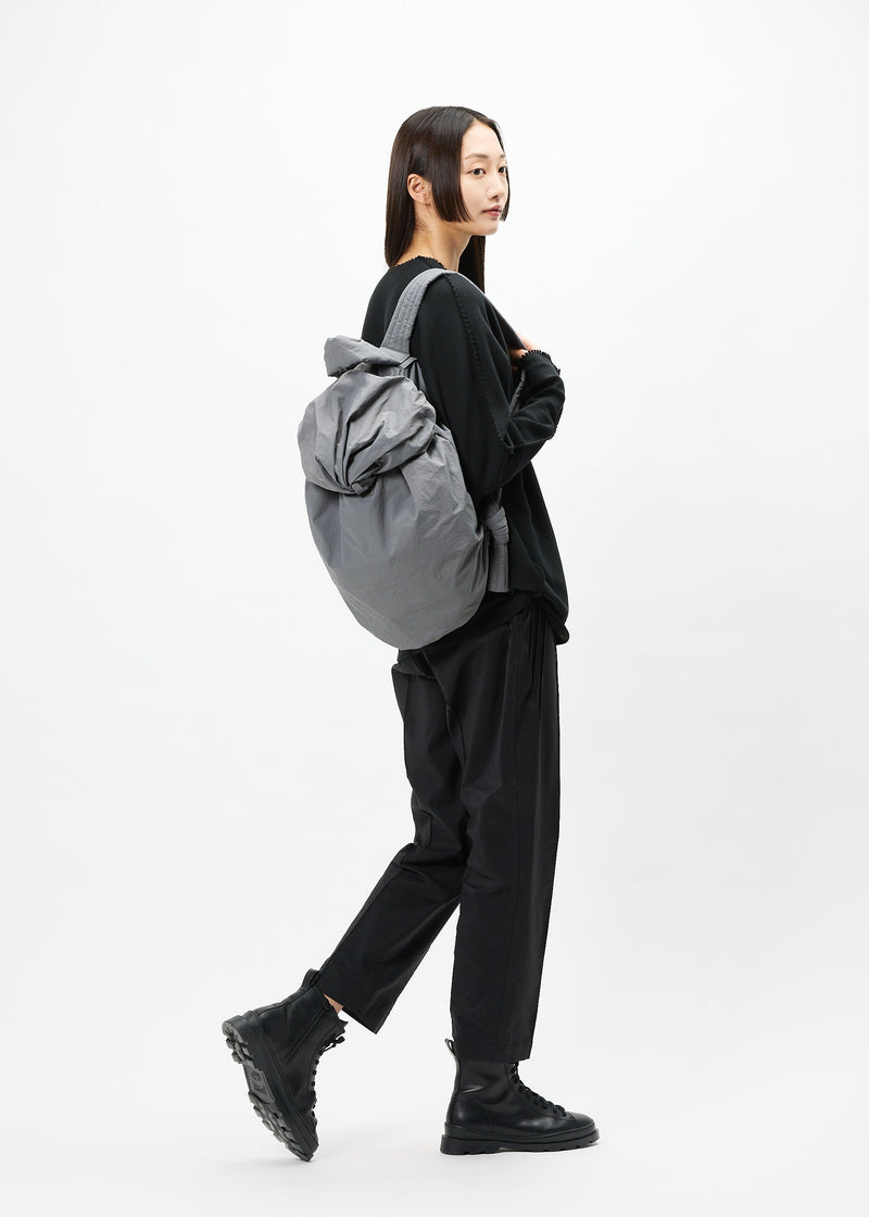 A model wears the GOOD GOODS ISSEY MIYAKE FUWA FUWA bag.