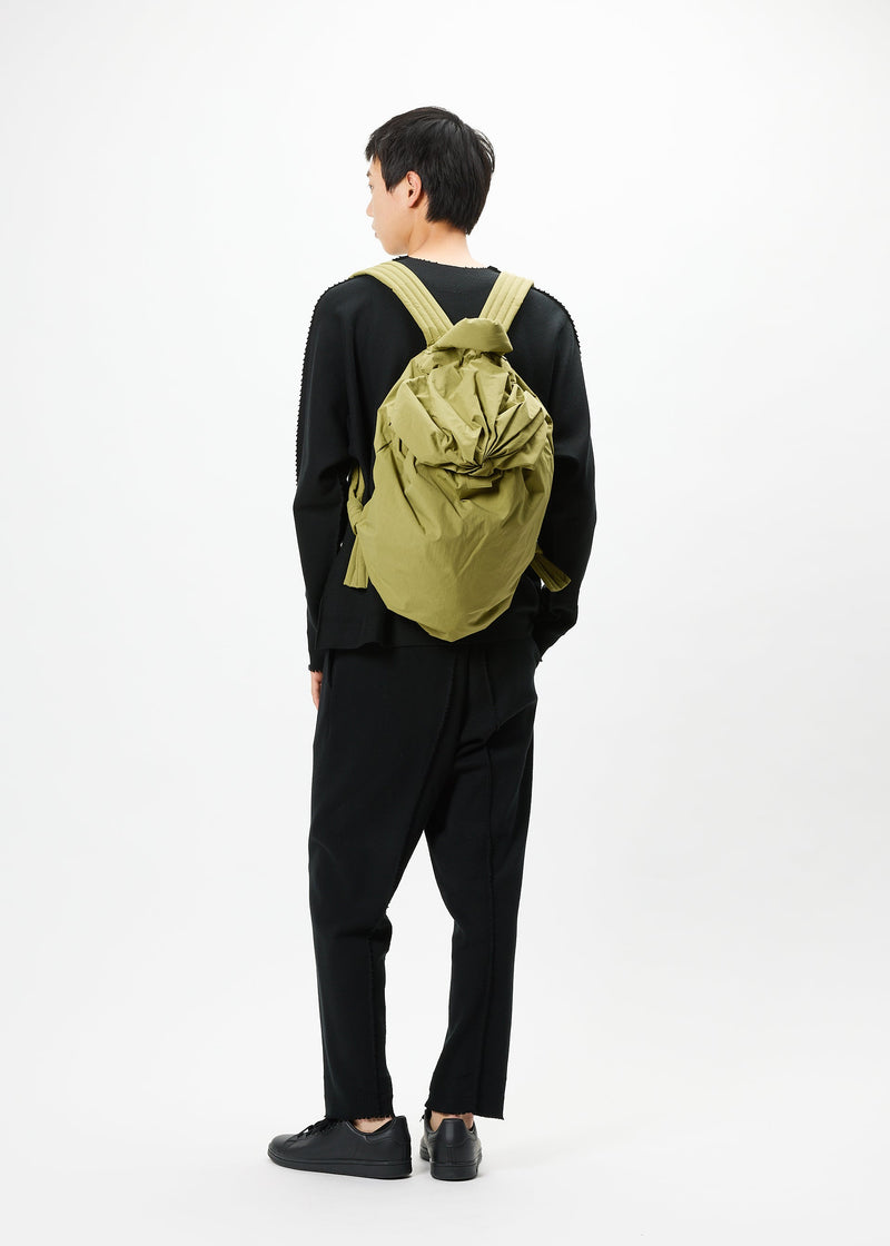 A model wears the GOOD GOODS ISSEY MIYAKE FUWA FUWA bag.