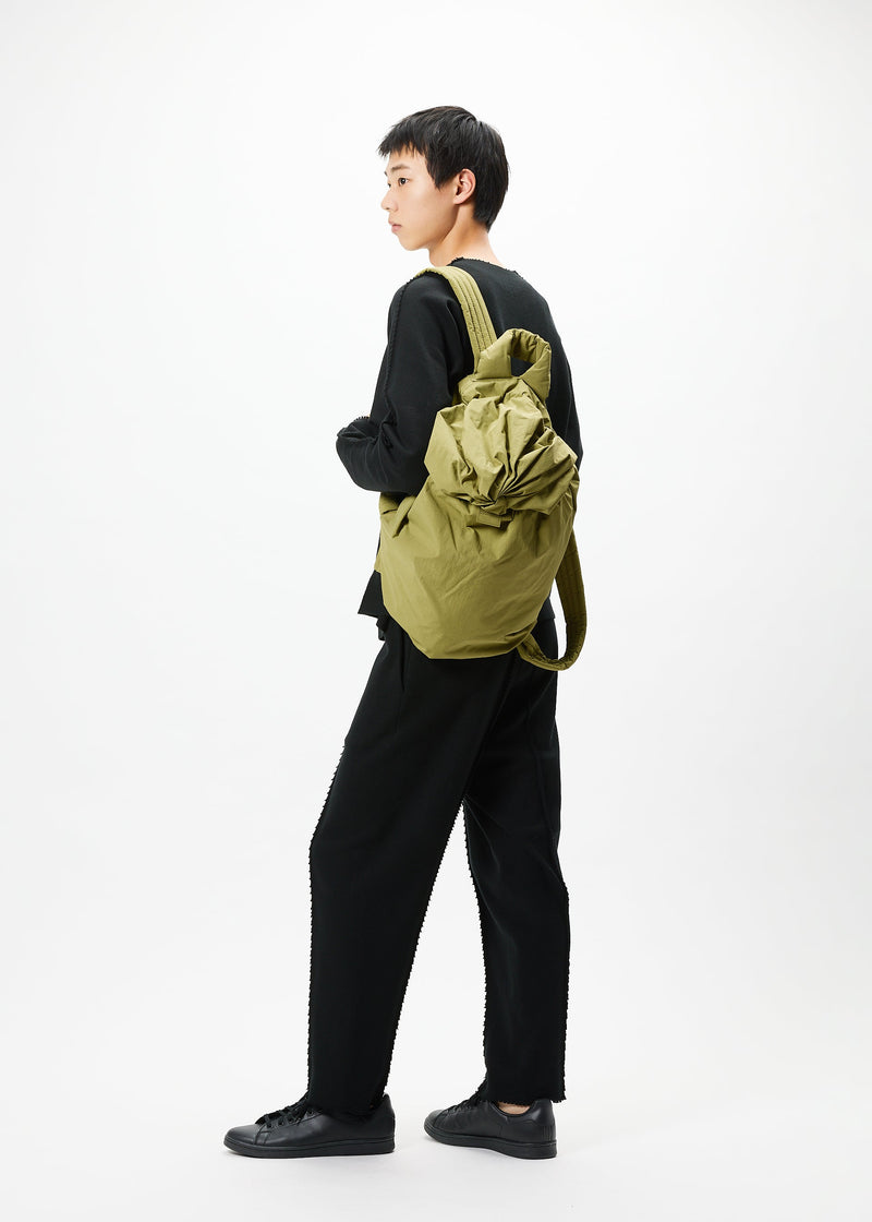 A model wears the GOOD GOODS ISSEY MIYAKE FUWA FUWA bag.