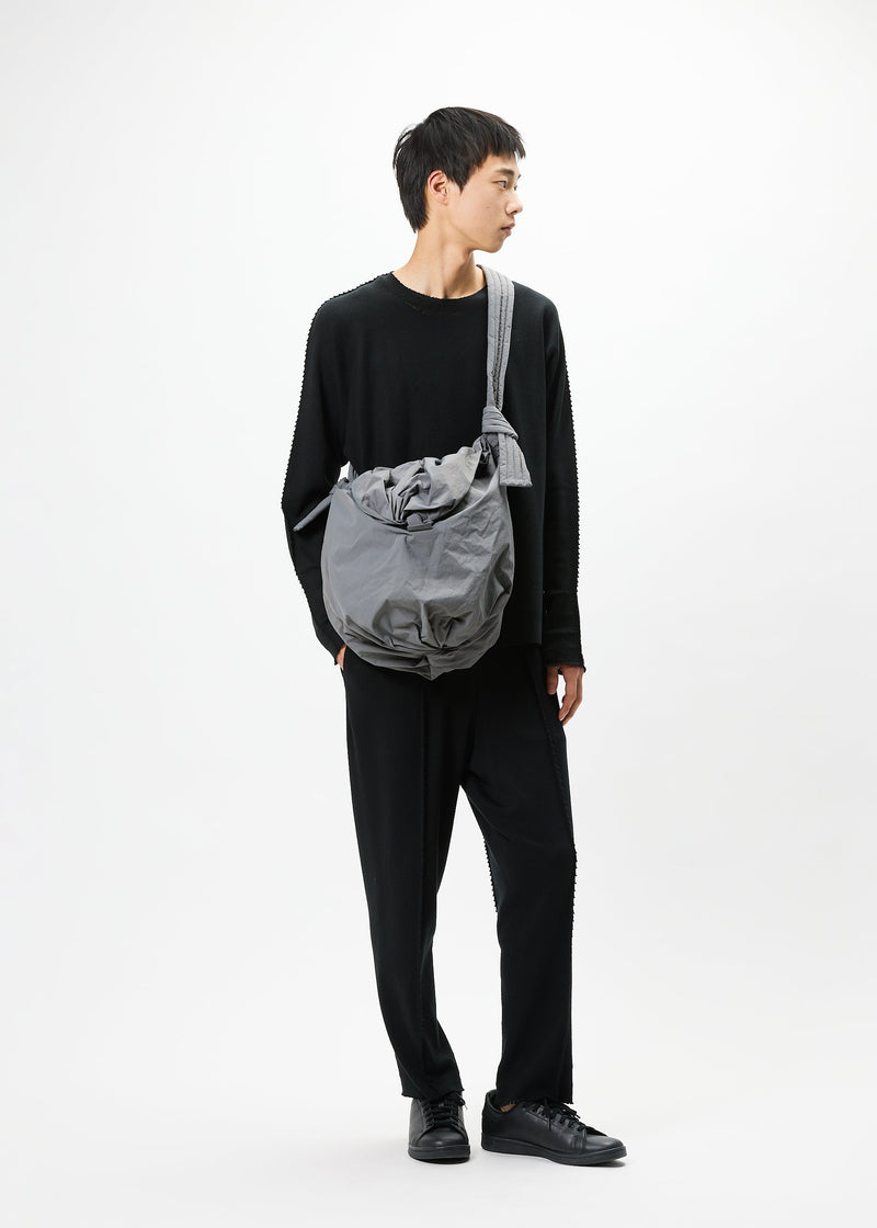 A model wears the GOOD GOODS ISSEY MIYAKE FUWA FUWA bag.