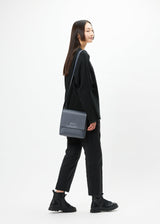 A model wears the GOOD GOODS ISSEY MIYAKE BOX bag.