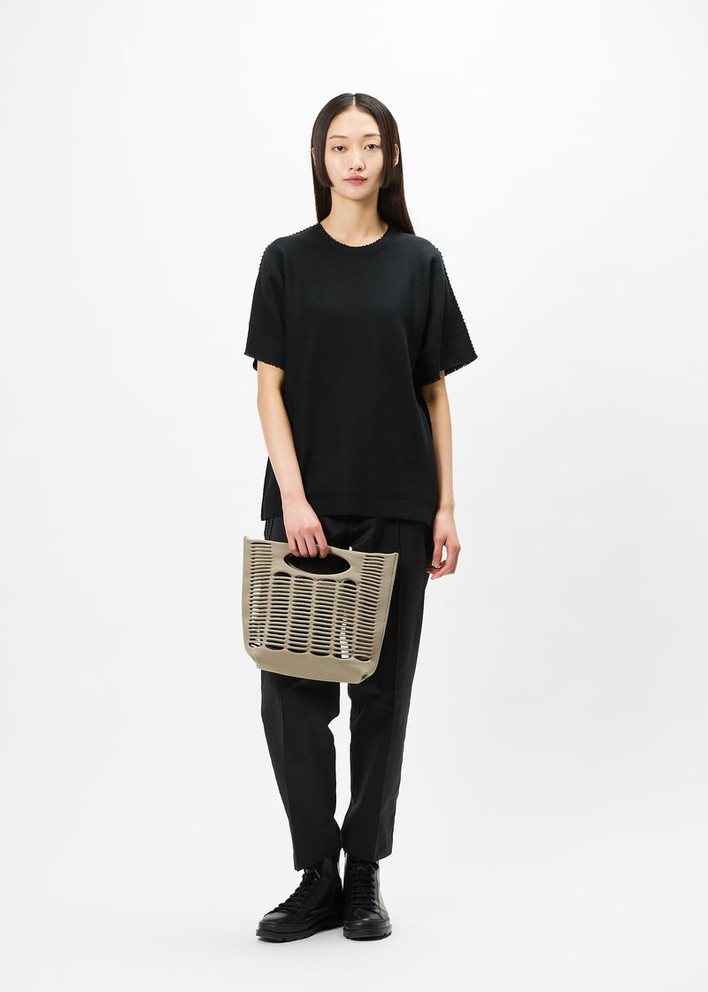 A model wears the GOOD GOODS ISSEY MIYAKE MOKKO bag.