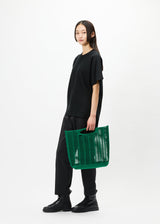 A model wears the GOOD GOODS ISSEY MIYAKE MOKKO bag.