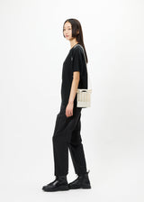 A model wears the GOOD GOODS ISSEY MIYAKE MOKKO bag.