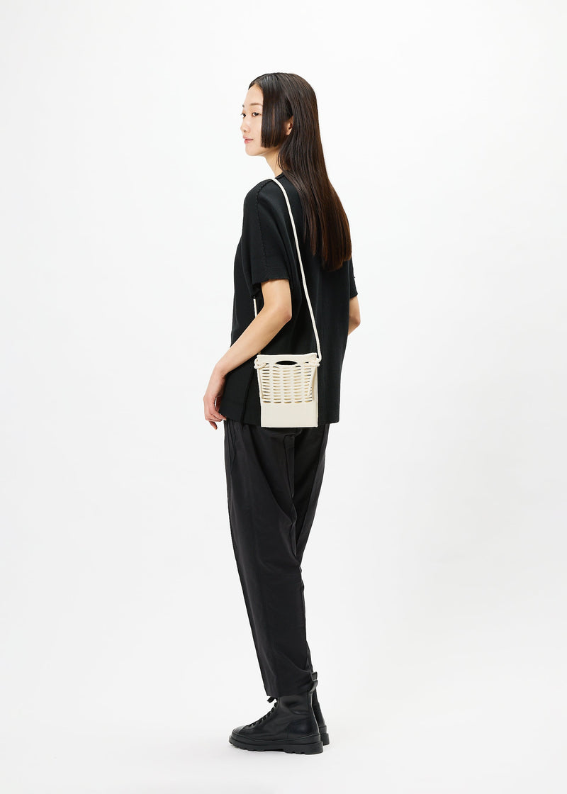 A model wears the GOOD GOODS ISSEY MIYAKE MOKKO bag.